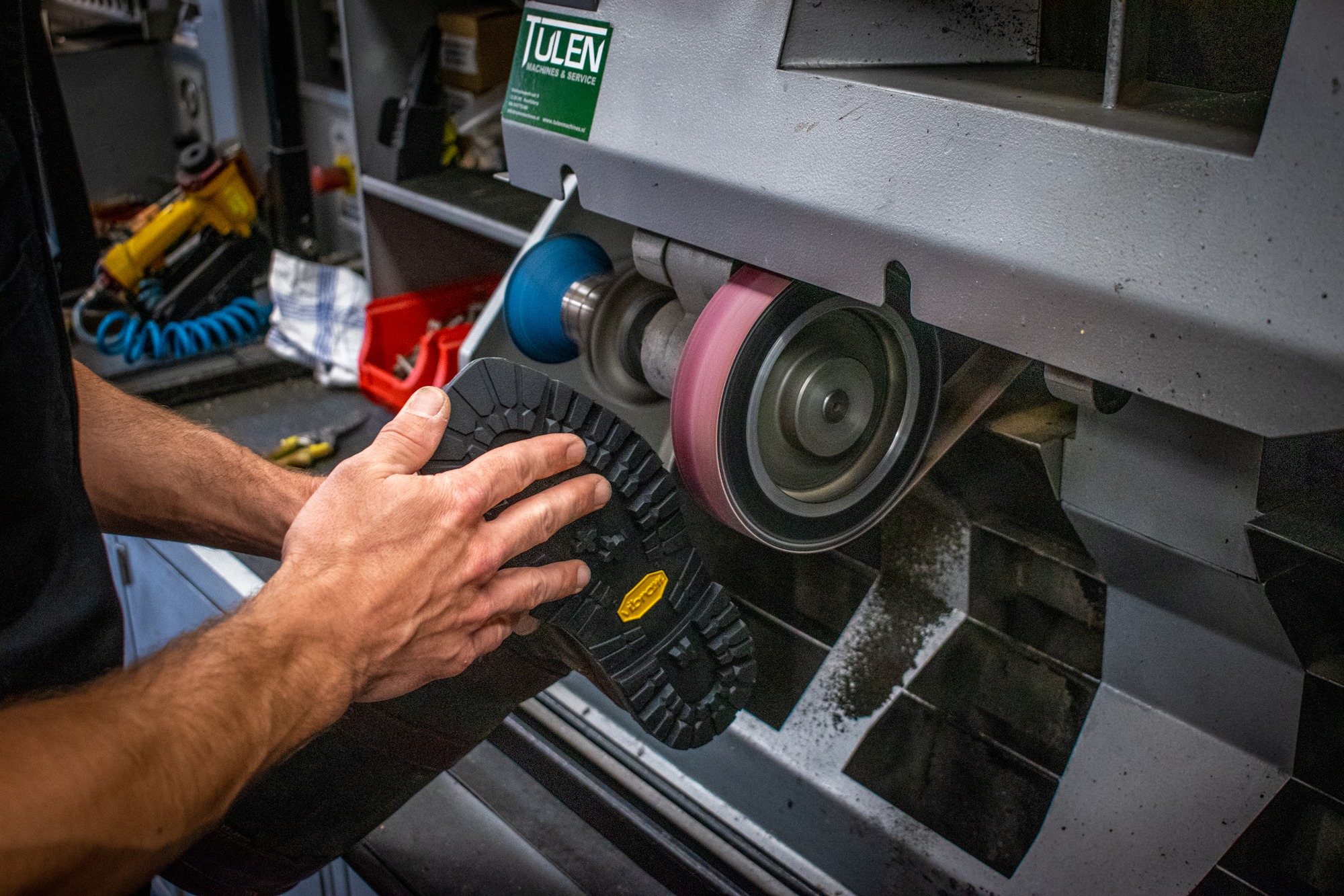 Detail van laarzen tijdens een reparatie met gereedschap